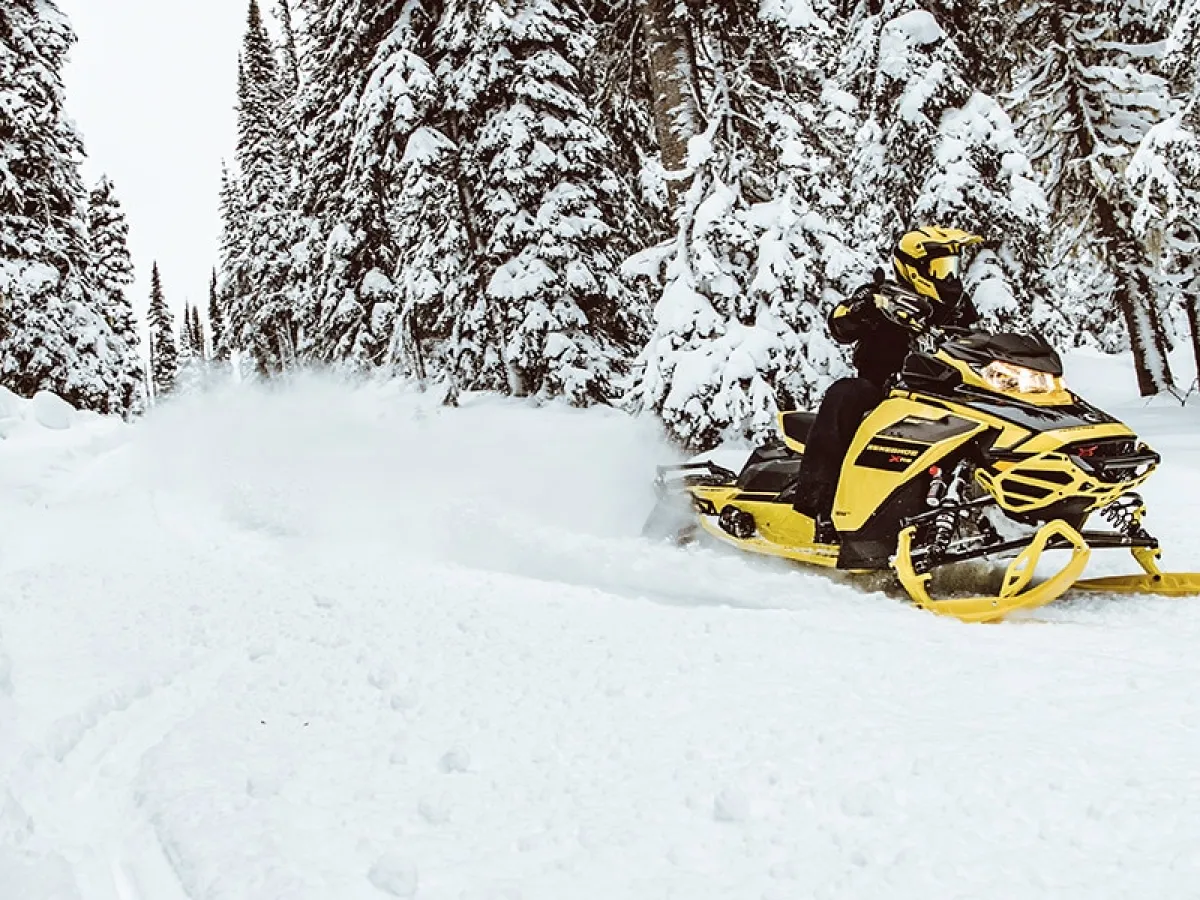 a man riding a snowboard down a snow covered slope