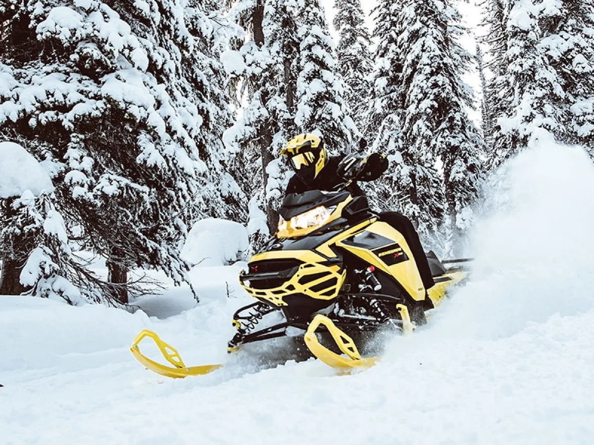 a man riding a snowboard down a snow covered slope