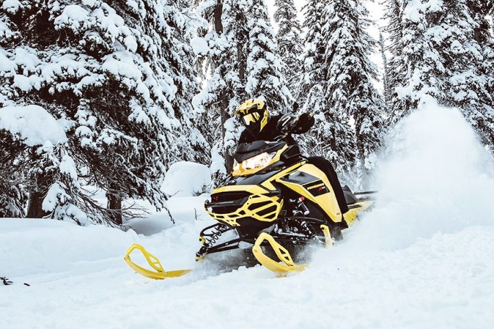 a man riding a snowboard down a snow covered slope