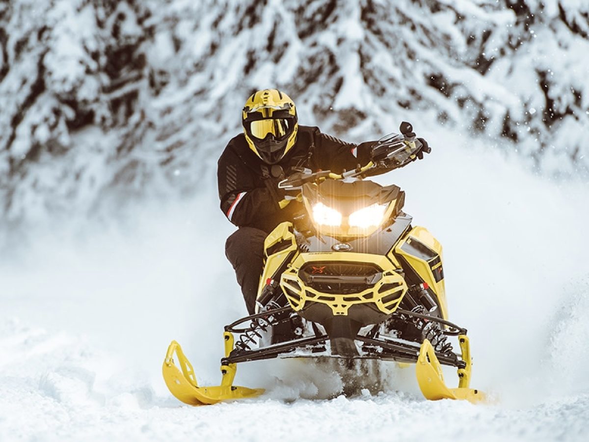 a man riding a snowboard down a snow covered slope