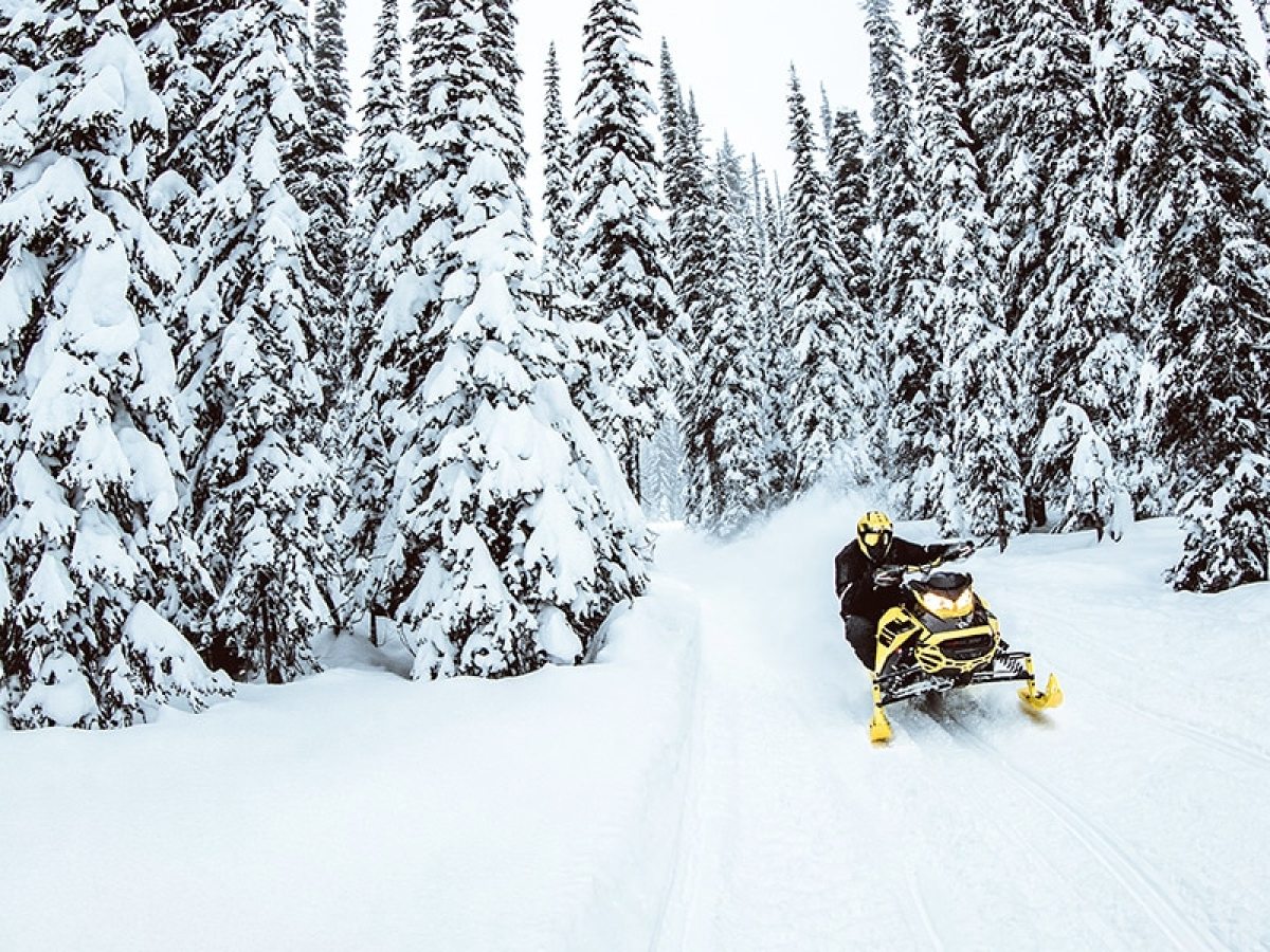 a man riding a snowboard down a snow covered slope