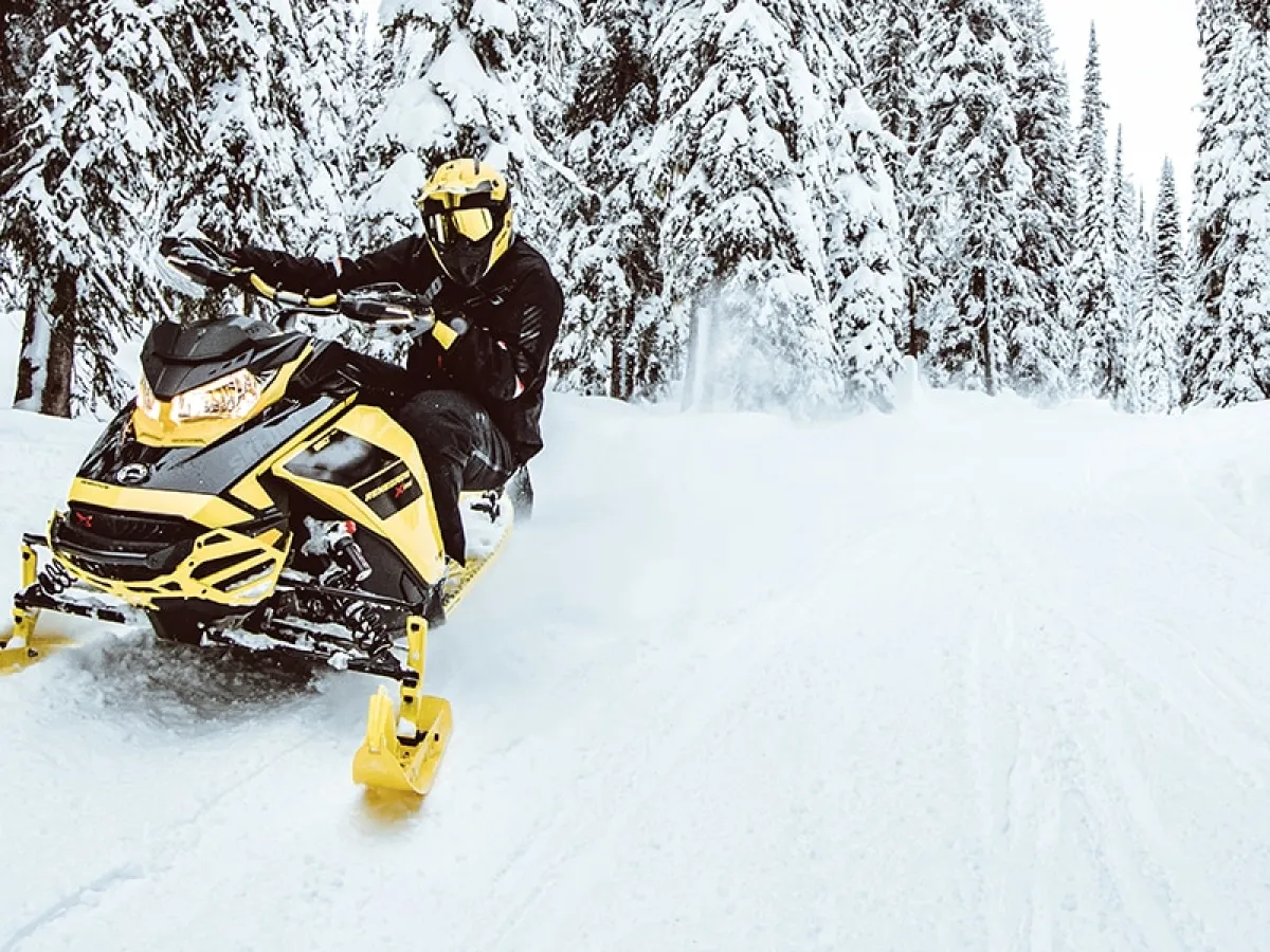 a man riding a snowboard down a snow covered slope
