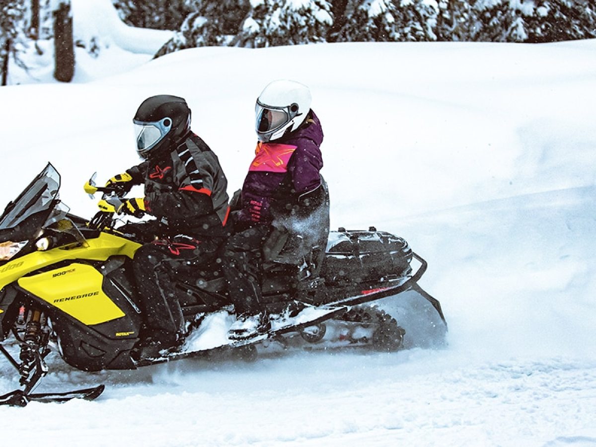 a man riding a snowboard down a snow covered slope